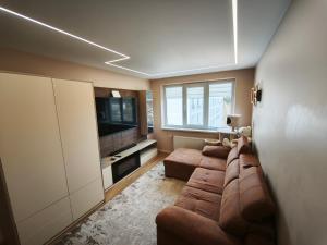 a living room with two couches and a flat screen tv at Panorama View Suite in Jelgava
