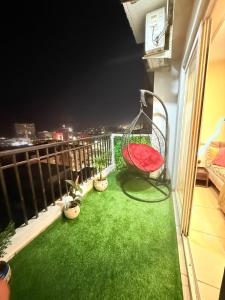 a balcony with a swing and green grass at Vetri Homes IV in Zirakpur +17 photos