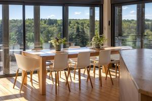 a dining room with a table and chairs and large windows at Maison Lotus - Groupes et familles, séjour Nature au coeur du Périgord Vert in Saint-Martial-de-Valette