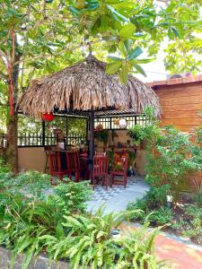 a hut with a table and chairs in a garden at Sun Nova Home Phu Quoc in Phú Quốc