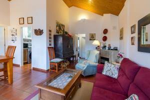 a living room with a purple couch and a table at Las Camelias in Argoños