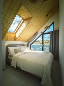 a bedroom with a large bed with a large window at Gródek & Ogródek in Gródek Nad Dunajcem