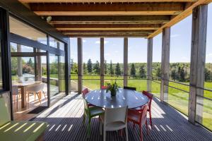 a glass house with a table and chairs on a deck at Maison Lotus - Groupes et familles, séjour Nature au coeur du Périgord Vert in Saint-Martial-de-Valette