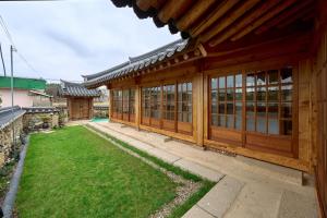 a wooden building with windows and a yard at Hanok Moonstay in Gyeongju