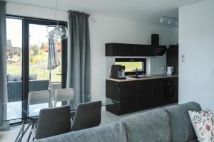 a living room with a couch and a glass table at Gródek & Ogródek in Gródek Nad Dunajcem