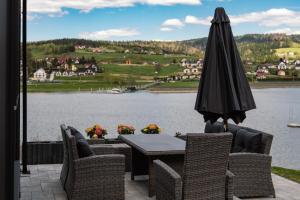 a table and chairs with an umbrella and a lake at Gródek & Ogródek in Gródek Nad Dunajcem +39 photos