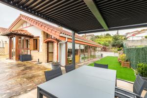 an outdoor patio with a white table and chairs at Las Camelias in Argoños