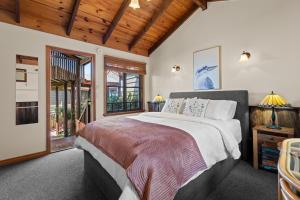 a bedroom with a large bed and a wooden ceiling at Tamborine Mountain Bed and Breakfast in Mount Tamborine