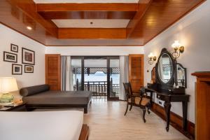 a living room with a couch and a table at Thavorn Beach Village Resort & Spa Phuket in Kamala Beach