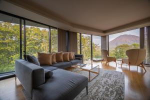 a living room with a couch and large windows at Kozue in Kutchan