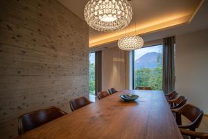 a dining room with a wooden table and a large window at Kozue in Kutchan