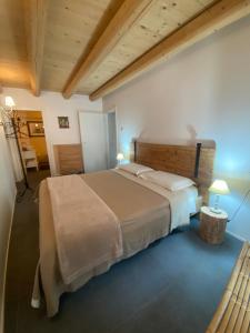 ein Schlafzimmer mit einem großen Bett und einer Holzdecke in der Unterkunft Pedegagia in Vezzano