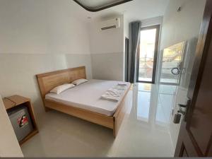 a small bedroom with a bed and a window at Nhà Nghỉ THÀNH LỘC in Long Hai