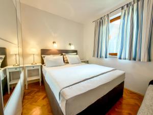 a bedroom with a large bed and a window at Jellyfish in Malinska