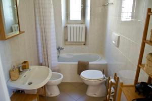 a bathroom with a sink and a toilet and a tub at Casa Corten, Vista Lago in Cerro Lago Maggiore +40 photos
