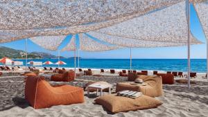 a beach with chairs and umbrellas and the ocean at Mitsis Rodos Maris in Kiotari