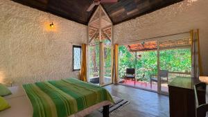 a bedroom with a bed and a large window at T Stop Farmhouse Coorg in Kurchi