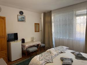 a bedroom with a bed and a television and a table at Семейна къща Боеви in Pomorie