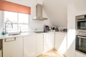 a white kitchen with white cabinets and a sink at York House in Aldeburgh +20 photos