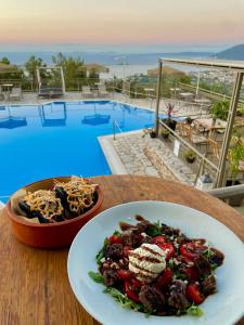 a plate of food on a table next to a bowl of pasta at Semiramis in Lefkada