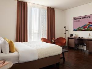 a hotel room with a bed and a desk and a computer at Numa Berlin Weinmeister in Berlin