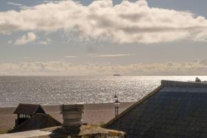 a view of the beach with a boat in the water at York House in Aldeburgh