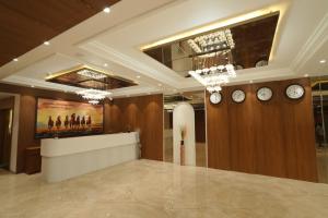 a lobby with clocks on the walls and a reception desk at The Grand Icon in Chandrapur