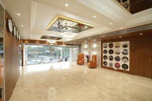 a lobby with chairs and a clock on the wall at The Grand Icon in Chandrapur