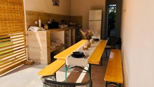a kitchen with a long wooden table and benches at Casa de Oaspeti 2 Mai in 2 Mai