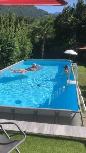 three people are swimming in a swimming pool at Conca Verde Appartaments in Bellagio +26 photos