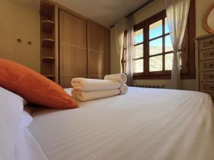 a bedroom with a bed with towels on it at AC Apartaments Canillo in Canillo