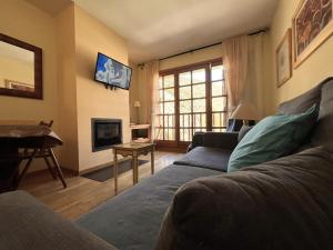a living room with a couch and a fireplace at AC Apartaments Canillo in Canillo