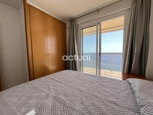 a bedroom with a bed and a view of the ocean at President A-9 in Platja d'Aro