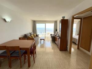 a living room with a table and a room with a bed at President A-9 in Platja d'Aro