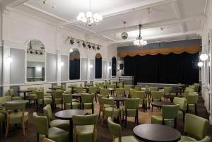 a room filled with tables and chairs at The Caledonian Torbay Hotel in Torquay