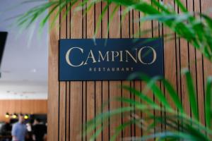 a sign for campino restaurant on a wooden wall at Longue vie Hotels in Marrakesh