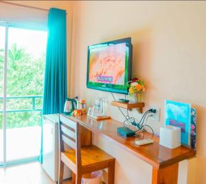 a room with a desk with a television on a wall at Ingtarn Ressort At thasala อิงธารรีสอร์ท ท่าศาลา in Ban Nai Thung