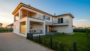 a large white house with a grass yard at Casa de Oaspeti 2 Mai in 2 Mai