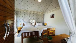 zwei Betten in einem Zimmer mit weißer Bettwäsche in der Unterkunft Escape Pod Himalayan Campsite in Bhīm Tāl