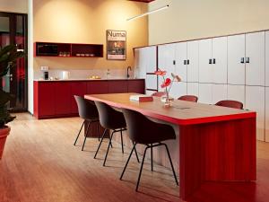 a kitchen with a large wooden table and chairs at Numa Berlin Weinmeister in Berlin
