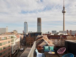 a view of a city from a balcony with chairs and tables at Numa Berlin Weinmeister in Berlin