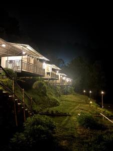 eine Häuserreihe auf einem Hügel bei Nacht in der Unterkunft Escape Pod Himalayan Campsite in Bhīm Tāl