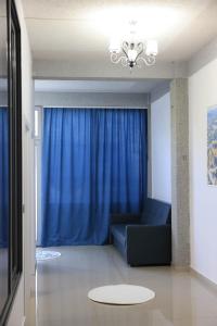 a living room with a couch and a blue curtain at Ergi Riverside Villas in Zues