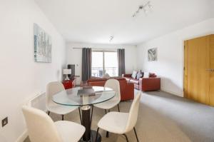 a living room with a table and chairs and a couch at 16 John Walker House River Views, Parking and Lift in York +8 photos