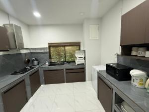 a kitchen with a sink and a counter top at The Hide Private in Ban Non Sa-at