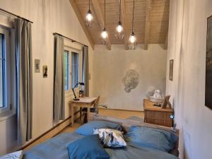 a bedroom with a bed and a desk and lights at Chesa Clavazzin in Brunnadern