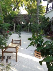a park with a bench in the sand and trees at The Twende Villa on Beach in Paje