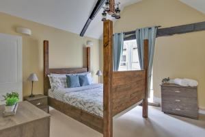 a bedroom with a wooden bed and a window at Finest Retreats - Josua, Maldon in Maldon