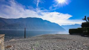 a body of water with mountains in the background at Historic Borgo Lake Como Campidoglio 3 in Lenno