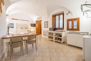 a kitchen with white cabinets and a table and chairs at Historic Borgo Lake Como Campidoglio 3 in Lenno